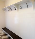Mud room with wainscot on the wall with coat hooks