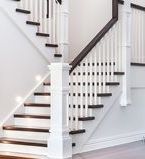 Wood and wrought iron staircase with board wall treatment along the side