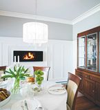 Salle à diner avec murs beige, cadrages blanc et meubles avec détails argentés