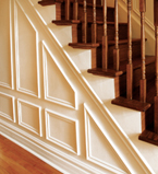 Oak staircase with white paneling along the side of the staircase