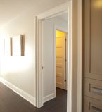 Light beige walls with white casing around doorway and white baseboards along the bottom of the wall