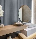 Traitement de mur de lambris gris bleu dans la salle de bain avec miroir rond