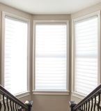 Three large windows on staircase landing with thin white casing around the windows