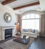 Light beige walls with white moulding and casing around large window with brown columns on the ceiling