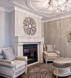 Salon avec murs beiges, cadrage blanc et meuble avec accents métalliques